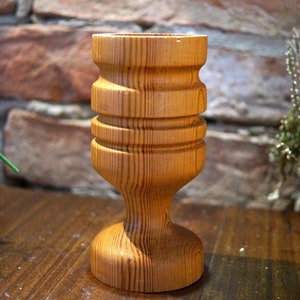 Peut inclure: Un gobelet en bois avec une finition en bois naturel. Le gobelet a une base large et un sommet étroit, avec un design unique comportant trois bandes de bois.