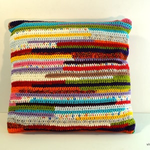 May include: Multicolored striped crocheted pillow with a variety of colors including red, orange, yellow, green, blue, purple, and brown.