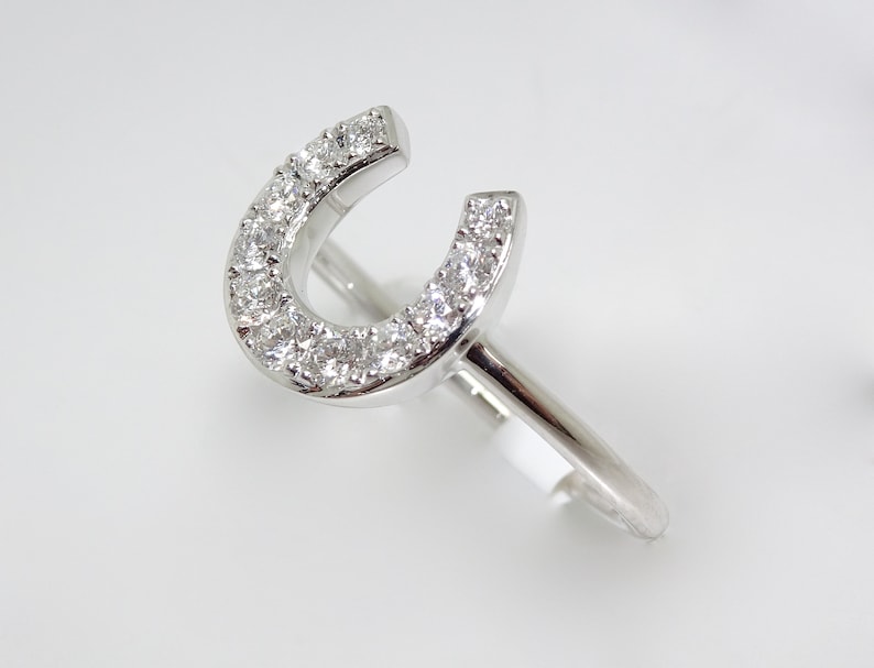 May include: A silver ring with a horseshoe design set with small diamonds.