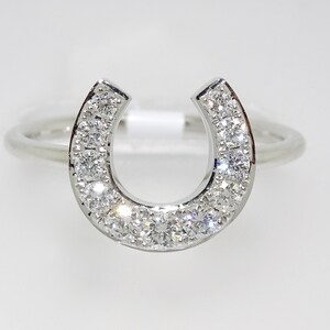 May include: A silver ring with a horseshoe design set with small diamonds.