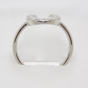 May include: A silver ring with a heart-shaped design set with small diamonds.