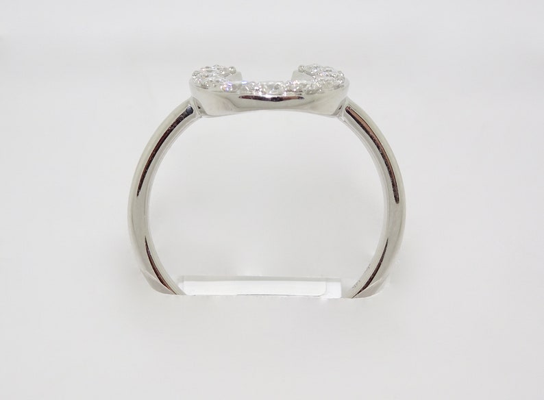 May include: A silver ring with a heart-shaped design set with small diamonds.