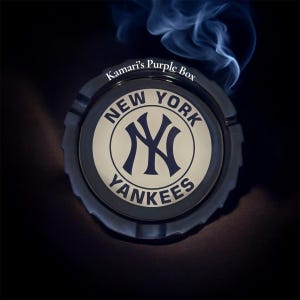 May include: A black ashtray with the New York Yankees logo in the center. The logo is a navy blue interlocking NY on a cream-colored background, surrounded by the words "NEW YORK" and "YANKEES". The text "Kamari's Purple Box" is printed on the rim.