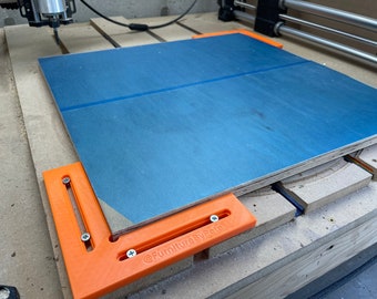 Puede incluir: Una pieza de madera azul está siendo cortada por una máquina CNC. La madera está sujeta en su lugar con abrazaderas naranjas. El texto "@FurnitureByPete" es visible en una de las abrazaderas.