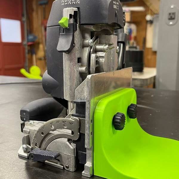 May include: A green and black power tool with a depth gauge and a protractor. The tool has a depth gauge with markings for 12, 15, 20, 25, and 28. The protractor has markings for 60, 70, 80, and 90 degrees.
