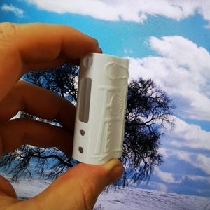 Könnte beinhalten: Weißes Silikon-Case für eine elektronische Zigarette. Das Case hat ein strukturiertes Design mit einem erhabenen Muster.