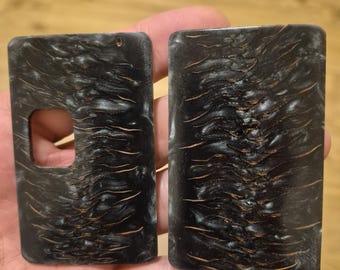 May include: Two rectangular panels featuring a dark, textured surface with a swirling, organic pattern of black and deep brown tones. One panel includes a square cutout on the left side, while the other is solid. Both pieces have rounded corners.