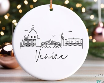 May include: White ceramic Christmas bauble featuring a black line drawing of the Venice skyline, including the Rialto Bridge, and the text "Venice".