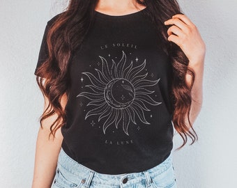 May include: A black t-shirt with a white graphic of a sun and moon with the text "Le Soleil" and "La Lune" in French.