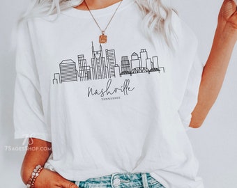 May include: White t-shirt with a black line drawing of the Nashville skyline and the text "Nashville, Tennessee".