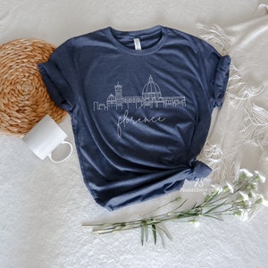 May include: A navy blue t-shirt with a white outline of the Florence skyline and the word "Florence" underneath.