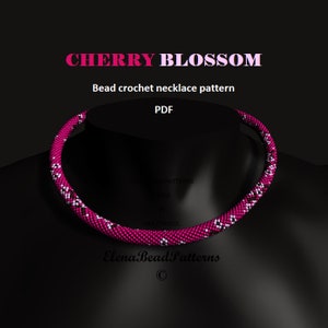 May include: A magenta bead crochet necklace displayed on a black mannequin. The necklace features a repeating pattern of magenta, black, and white beads. The text "CHERRY BLOSSOM" and "Bead crochet necklace pattern" are visible in the image.