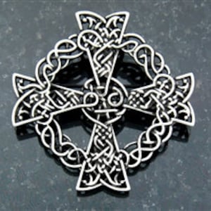 May include: A silver Celtic knot cross pendant with intricate designs. The cross is surrounded by a circle of knots.