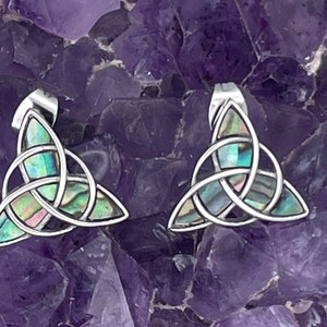May include: A pair of silver earrings with a Celtic knot design. The knots are filled with iridescent abalone shell.