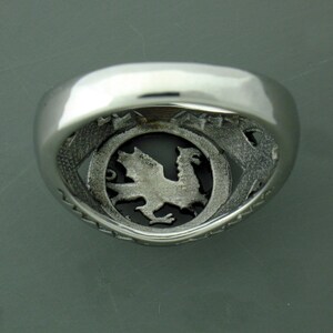 May include: Silver ring with a detailed dragon design inside the band.