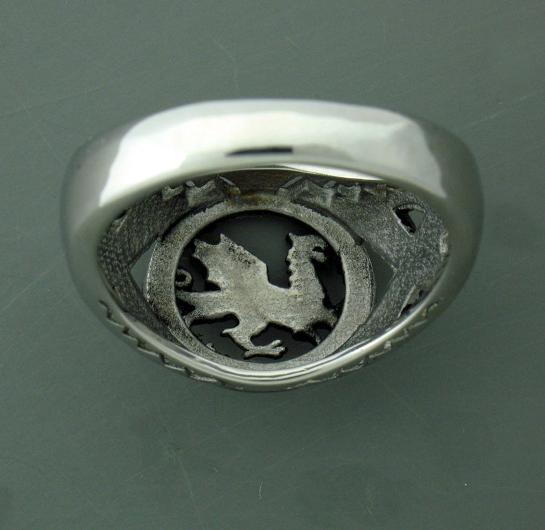 May include: Silver ring with a detailed dragon design inside the band.