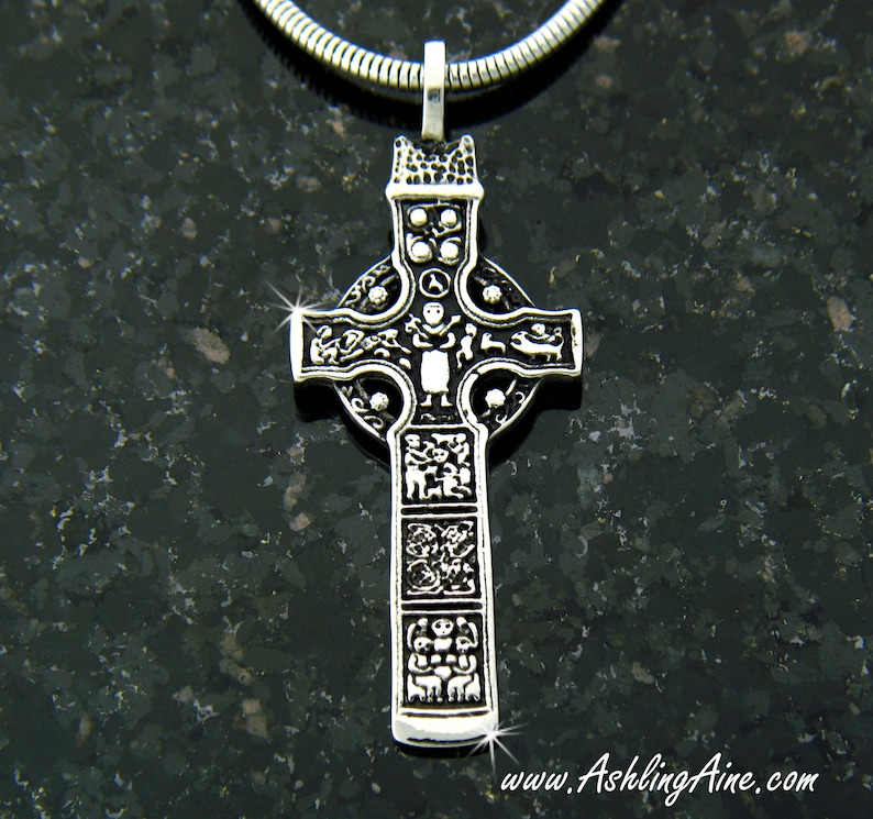 May include: A silver Celtic cross pendant with intricate designs and a circle around the center. The cross is detailed with various figures and symbols.