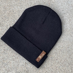 May include: Black beanie with a brown leather patch that says "G. Brown" in gold lettering.