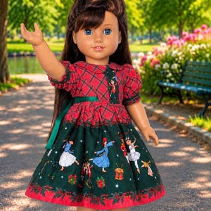 May include: A doll with long brown hair and blue eyes wearing a dress with a red plaid bodice and a dark green skirt featuring a printed pattern of dancers, drums, and gifts. The dress has short sleeves, a collar, and a green ribbon at the waist.