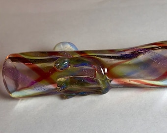 May include: A glass pipe with a swirling pattern of red, yellow, blue, and white. The pipe has a small, clear glass mouthpiece and a larger, clear glass bowl.