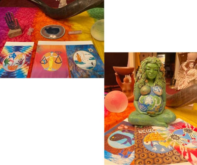 May include: A collection of spiritual and artistic items, including painted art pieces, a green statue of a pregnant woman with the Earth on her belly, and decorative crystals. The art pieces feature celestial and symbolic imagery.