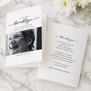 May include: A white memorial card with the name "Brooklyn Ellington" and dates "October 19, 1938 - June 4, 2026". The card includes a black and white photo and the words "Forever With Us". The inside reads "thank you".