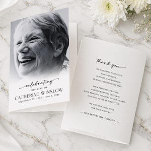 May include: A folded funeral thank you card featuring a black and white portrait of an elderly person. The front reads celebrating the life of Catherine Winslow, 1942-2026. The inside text expresses gratitude for love, support, and kindness.