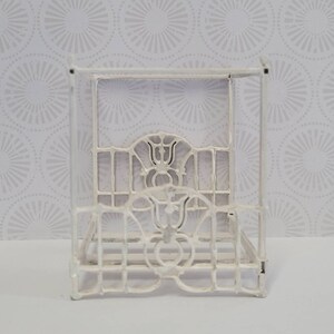 Puede incluir: Estructura de cama con dosel de metal blanco con detalles intrincados. El marco est&aacute; hecho de metal delgado y tiene un dise&ntilde;o delicado y ornamentado.