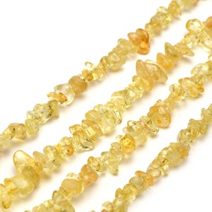 May include: A strand of yellow citrine chip beads. The beads are irregular in shape and have a translucent appearance.