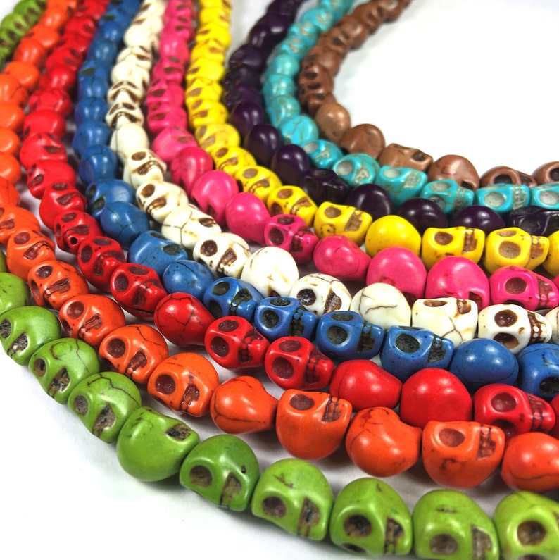 Puede incluir: Una hebra multicolor de cuentas con forma de calavera. Las cuentas est&aacute;n hechas de turquesa y son de tonos verdes, azules, rojos, naranjas, amarillos, blancos y rosas.