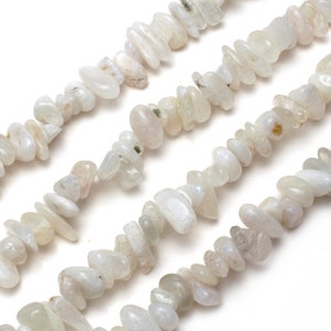 May include: Strands of off-white, irregular-shaped gemstone beads. The beads have a polished, smooth surface and vary in size. The color is a soft, creamy white with subtle variations. The beads are strung together, creating a necklace or bracelet.