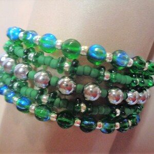 May include: A multi-strand bracelet with green and blue glass beads and silver metal beads.