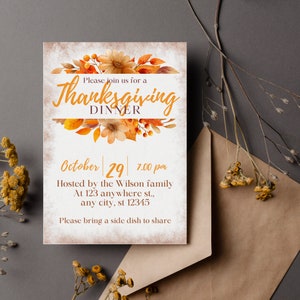 May include: A Thanksgiving dinner invitation with a watercolor illustration of fall leaves and flowers. The invitation reads "Please join us for a Thanksgiving Dinner, October 29, 7:00 pm. Hosted by the Wilson family at 123 anywhere st., any city, st 12345. Please bring a side dish to share."
