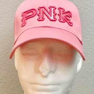 May include: Pink baseball cap with a white embroidered "PNK" logo.