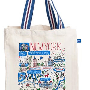 Può includere: Borsa tote color crema con manici a righe blu e rosse. La borsa presenta una mappa illustrata colorata dello Stato di New York, inclusi punti di riferimento e il testo "NEW YORK THE EMPIRE STATE".