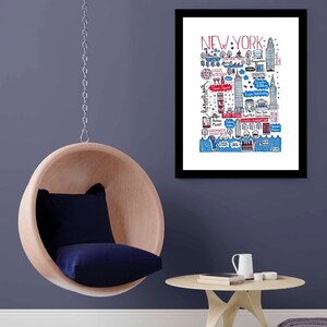 May include: A framed art print featuring a hand-drawn map of New York City in red, blue, and black ink on a white background. The illustration includes labelled landmarks like Central Park, Times Square, and the Statue of Liberty with detailed line work.