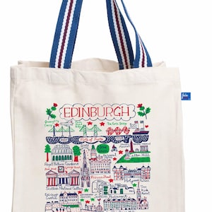 May include: Cream-colored tote bag featuring a colorful illustrated map of Edinburgh, Scotland. The map includes landmarks like the Forth Bridge and Edinburgh Castle. The bag has blue and white striped handles. The word "EDINBURGH" is at the top.