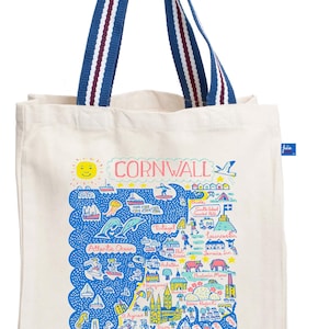 Può includere: Borsa tote color crema con manici a righe blu e bianche. La borsa presenta una mappa colorata della Cornovaglia, in Inghilterra, con la scritta "CORNWALL" in alto. La mappa include illustrazioni di punti di riferimento e dell'Oceano Atlantico.