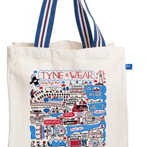 Puede incluir: Bolso tote color crema con asas a rayas azules y rojas. El bolso presenta un mapa ilustrado colorido de Tyne & Wear, incluyendo Newcastle, Sunderland y Gateshead. El texto "TYNE & WEAR" está en la parte superior.