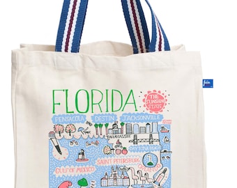 May include: A cream-coloured tote bag with blue and white striped handles. The bag displays a colourful map of Florida with city names and illustrations. The word "FLORIDA" is printed in green.