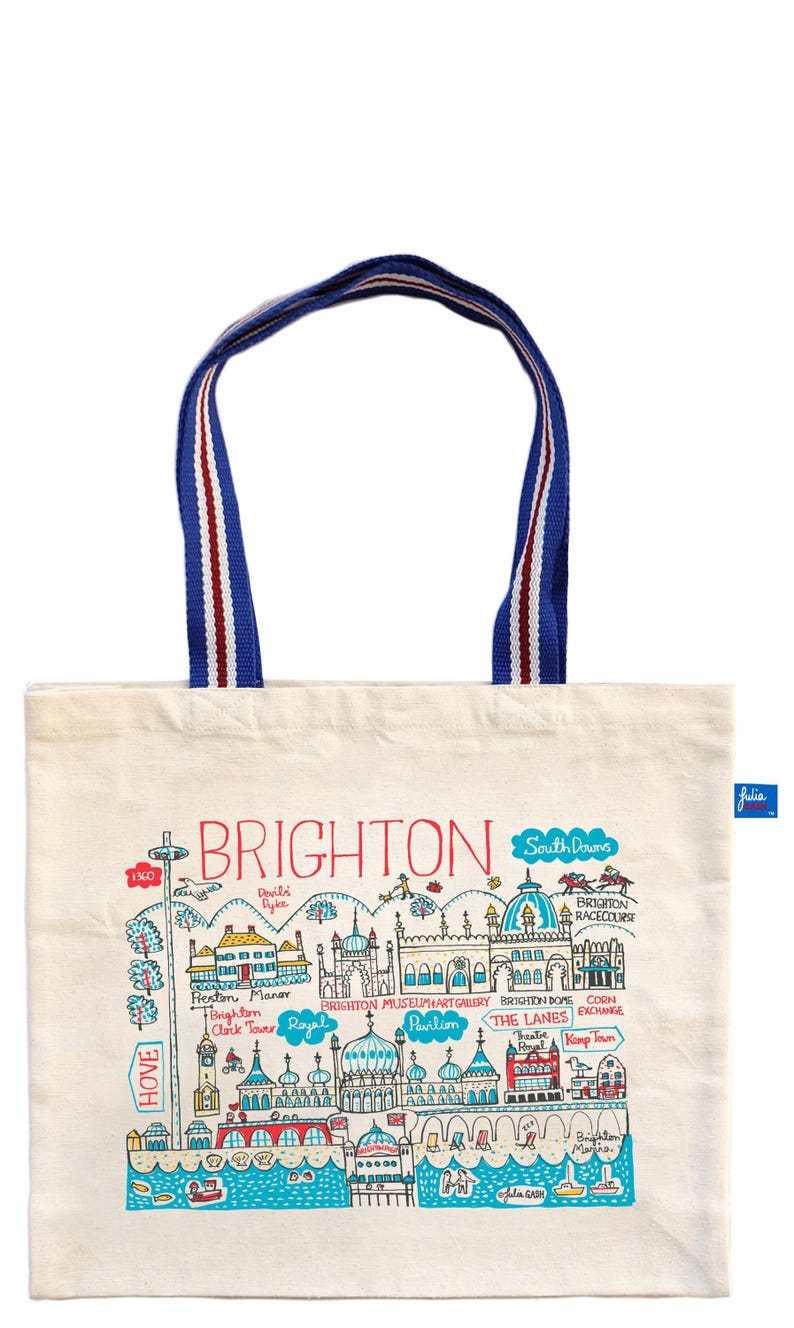 May include: Cream-colored tote bag featuring a colorful illustrated map of Brighton, England, with landmarks and the word "BRIGHTON" in red. The bag has blue handles with red and white stripes.