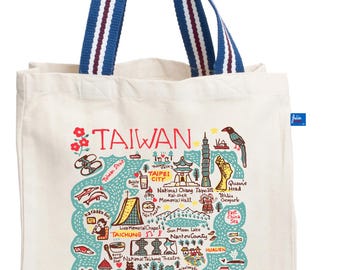 May include: A cream-colored canvas tote bag with blue and white striped handles. The front features a colorful illustrated map of Taiwan, including landmarks like Taipei 101, Sun Moon Lake, and various local icons with text labels.