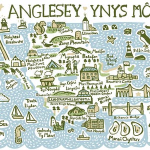 Puede incluir: Mapa ilustrado de Anglesey, Gales, con lugares emblemáticos como el castillo de Beaumaris, el puente Menai y Puffin Island. El mapa utiliza tonos verdes, azules y beige, con texto en estilo manuscrito.