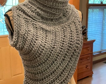 May include: Gray crocheted cowl neck sweater with a short, sleeveless design.