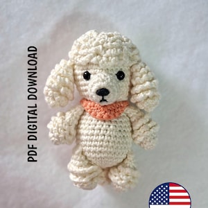 May include: A cream-colored crocheted poodle toy with curly yarn texture, black bead eyes, a black stitched nose, and a peach-colored collar. The text PDF DIGITAL DOWNLOAD is printed vertically on the left, and a small United States flag icon is present.