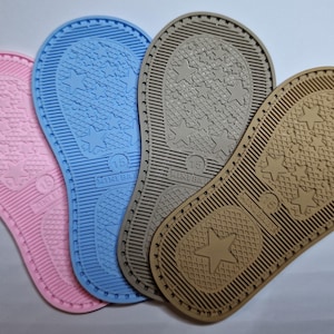Puede incluir: Cuatro plantillas de zapatos coloridas en rosa, azul, gris y beige. Cada plantilla tiene un patrón de estrellas y el número 15. Las plantillas están diseñadas para zapatos de niños.