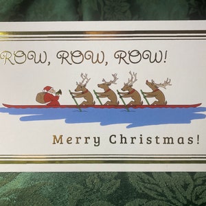 May include: Christmas card with a gold border featuring Santa Claus and reindeer rowing a boat. The text "ROW, ROW, ROW!" and "Merry Christmas!" are in gold lettering.