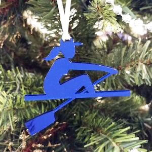 May include: A blue silhouette of a person rowing in a boat, a Christmas ornament.