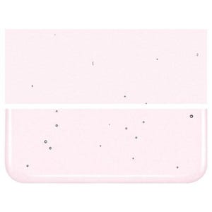 Peut inclure: Gros plan sur un récipient rectangulaire translucide rose pâle avec un fond légèrement arrondi. Le récipient est rempli d'un liquide clair et présente de petites taches sombres.