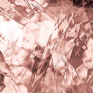 May include: A close-up of a crumpled piece of rose gold foil. The foil has a metallic sheen and is wrinkled and textured.